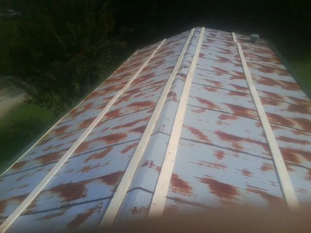 Rusted metal roof panels with new wood purlins before replacement — Storm Damage Roof Repair in Parksville by Roofing Brothers